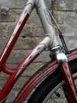 Zeitraum: 1956 bis 1960 Zu finden an: Tourenrädern und Tourensporträdern Beschreibung: Strahlenkopf (einfacher Strahl an der Gabel; silber mit farbigen Spitzen)