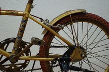 Der originale, goldfarbene Lack ist wurde auch auf Schutzbleche samt deren Befestigungstreben und -klemmen gesprüht. Der Fahrradständer wurde nachträglich angebracht.