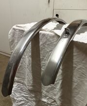 Zeitraum: etwa 1958-1960 Verwendung: Modell 9 e, Modell SH 14/2, ab 1959 Modell SH 14/1 Material: Aluminiumblech Größen: 26 Zoll, 28 Zoll Aussparung für Stempelbremse nein Überstand des Vorderrad-Schutzleches: lang Farben/Varianten: blank Profil: flach; ungesickt Bemerkungen: schmale Ausführung; unliniert