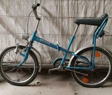 Ein mit Ausnahme der Luftpumpe vollständig erhaltenes Modell 405/3, Scheinwerfer und Speichenreflektoren vermutlich nicht original. Die originalen Blockpedale haben sich bereits größtenteils aufgelöst, auch das verbogene Schutzblech ist typisch.