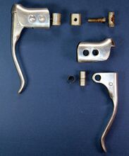 Bremsgriff mit Doppelbolzen Zeitraum: 1957 bis 196x Verwendung: Modelle Diamant#Diamant Rennräder Material: Aluminium Bemerkungen: ein Bolzen als Scharnier für den Hebel und einer zur Befestigung am Lenker - direkte Verschraubung mit Aluklötzchen im Lenker (oben-mittig); keine Schellenbefestigung möglich