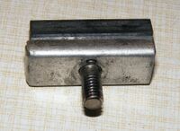 Bremsbelag in Halterung aus Aluminium. Befestigt wurde sie mit einer Hutmutter. Auch die Halterung wurde unverändert seit den 50er Jahren bis 1990 hergestellt.