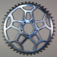 Diamant-Kettenblatt Zeitraum: 194x bis 1954 Verwendung: Diamant Modell 104 und 105 Material: Stahl (verchromt) Befestigung: 5-Punkt-Befestigung (50 mm Lochkreisdurchmesser) Größe: 46 Zähne Zahnbreite: 2,8 mm (für 1/8"-Kette) Bemerkungen: charakteristische "Diamant-Kelche" als Streben