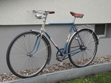 Aufgrund einiger Ausstattungsdetails mutet dieses Fahrrad noch vergleichsweise "klassisch" an, wozu unter anderem die Lenkergriffe aus Duroplast sowie der FER-Scheinwerfer mit separatem Frontring...