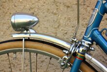 Zeitraum: 1956 bis 1958 Verwendung: Luxus-Sporträder Material: Alumimiumblech Größen: 28 Zoll Aussparung für Stempelbremse nein Überstand des Vorderrad-Schutzleches: extra-lang, mit innenverlaufender Strebe vor der Gabel Farben/Varianten: Alumimium blank Profil: flach, ungesickt Bemerkungen: Abschlüsse mit "Nase"