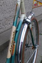 Dieses Oberrohr- und Gabelscheiden-Dekor wurde nur kurzzeitig 1964 verwendet. Zudem ist am Unterrohr das Touren-Sport-Schiebebild weiter unten platziert als es später üblich war. Die Nabenputzringe wurden erneuert.