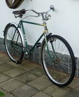 Modell EH von 1956 in Dunkelgrün mit beigem Strahlenkopf. Schutzbleche vrmtl. neu lackiert, Scheinwerfer ist Zubehörteil. Gepäckträger fehlt.