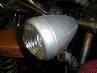 Zeitraum: 195? bis 195? Verwendung: Zubehörteil Material: Aluminium, Glas Bemerkungen: kleines Logo oben im Lampenglas; mit Fahr- und Bodenlicht (Ausführung mit schwarzem Umschalter)