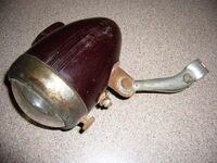 Zeitraum: 195? bis 195? Verwendung: Zubehörteil Material: Duroplast, Glas, Stahlblech Bemerkungen: großes Logo mittig auf Streuscheibe sowie Kennzeichnung "Germany" am unteren Rand; mit Fahr- und Bodenlicht, Halterung nicht original