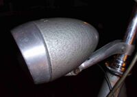 Scheinwerfer Typ 8707.15 Zeitraum: 1959 bis mind. 1965 Verwendung: Material: Stahlblech, Glas bzw. Kunststoff, Aluminium Ø Lichtaustritt: 60 mm Farben/Varianten: silber, Hammerschlaglack silber (im Bild) Bemerkungen: bis mind. 1962 mit Streuscheibe aus Glas