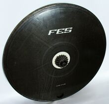 FES-Scheibenrad 28" aus CFK für Zeitfahrrad mit 6-fach-Ritzel. Unter den Seitenwänden zeichnen sich die einlaminierten Stützstreifen ab, die das Innere in sechs Segmente einteilen. In jedem Segment befinden sich außen weitere fünf kurze Stützstreifen.