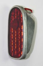 Rücklicht Typ 8507.6 Zeitraum: 1961 bis 1967 Verwendung: alle Fahrradtypen Material: Aluminium, Glas Farben/Varianten: silber, Aluminium blank (im Bild), Hammerschlaglack silber Bemerkungen: Mit innenliegender Klemmung des Beleuchtungskabels.