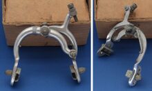 (GR)-Felgenbremse (Tourenausführung) Zeitraum: Verwendung: Zubehörteil Material: Aluminium Bemerkungen: lange Bremsschenkel, spezieller Befestigungswinkel (rechts im Bild) für Tourenräder ohne reguläre Bremsbohrung am Hinterbau