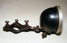 Rücklicht Typ RE 1 Zeitraum: 19xx bis 195x, hier: 1952 Verwendung: u.a. Simson, Diamant Material: thermoplast. Kunststoff (Decelith), Glas, Aluminium Farben/Varianten: schwarz Bemerkungen: Öffnung für Lampenfassung sitzt seitlich im Gehäuse. Nur mit IKA-Labelung des Glases, ansonsten identisch mit dem Melas-Rücklicht.