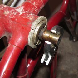 9. Rechte Kurbel demontieren Bei BSA-Lagern müssen dagegen beide Kurbeln entfernt werden, um das Lager vollständig warten zu können. Dazu wird die rechte Kurbel nach dem gleichen Verfahren gelöst. Sollte sich die Kurbel nach Entfernen des Keils nicht einfach von der Welle abnehmen lassen, kann die Welle mit dem Rollgabelschlüssel an der Planfläche der anderen Seite gehalten werden und die Kurbel so abgedreht werden. Keinesfalls sollte mit Zangen o.ä. an der Welle gearbeitet werden, weil durch Zangenabdrücke und Grate die präzise Passung zwischen Welle und Kurbel beschädigt werden könnte.