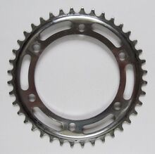 Einfachkettenblatt (klein) Zeitraum: 197x bis 1990 Verwendung: Zubehörteil Material: Stahl (verchromt) Befestigung: 3-Punkt-Befestigung (117 mm Lochkreisdurchmesser) Größe: 40 Zähne Zahnbreite: 2,1 mm (für 3/32"-Kette) Bemerkungen: häufig zusammen mit einem großen Kettenblatt kombiniert um eine große Übersetzungsbandbreite zu erreichen