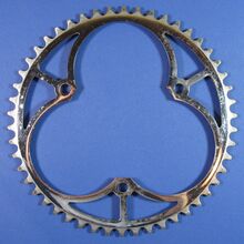 Kettenblatt für Getriebe-Typ 8036 (3/32"-Ausführung) Zeitraum: 1954 bis 1990 Verwendung: Diamant Rennräder (mit Vier- oder Fünfgang-Schaltung); Diamant Luxus-Sporträder und Modell 35 205 Material: Stahl (verchromt) Befestigung: 3-Punkt-Befestigung (117 mm Lochkreisdurchmesser) Größe: 46, 48, 50 oder 52 Zähne Zahnbreite: 2,1 mm (für 3/32"-Kette) Bemerkungen: -