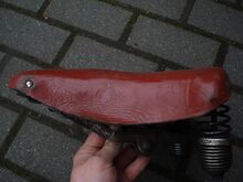 Tourensattel vom VEB Lederwarenfabrik Mühlhausen (Regulierfedern) Zeitraum: 195x bis 1955 Verwendung: Decke: Leder, lackiert Gestell: Stahl, verchromt Bemerkungen: Ausführungen für Damen- und Herrenräder, seltene Ausführung