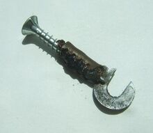 Spreizen der Kabelklemmung Mit Hilfe einer kleinen Schraube, die in die Kabelklemmung gedreht wird, läßt sich diese leicht aufspreizen. Kabelreste werden entfernt. die Enden des neuen (besser: gebrauchten) Kabels auf ca. einem Zentimeter abisoliert, umgelegt und eingeführt, wobei die Kontaktseite des Kabels an die Rückseite der Klemmung gehört. Mit einer Kombizange kann nun die Klemmung leicht wieder geschlossen werden.