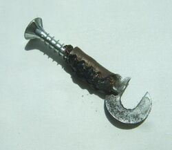 Spreizen der Kabelklemmung Mit Hilfe einer kleinen Schraube, die in die Kabelklemmung gedreht wird, läßt sich diese leicht aufspreizen. Kabelreste werden entfernt. die Enden des neuen (besser: gebrauchten) Kabels auf ca. einem Zentimeter abisoliert, umgelegt und eingeführt, wobei die Kontaktseite des Kabels an die Rückseite der Klemmung gehört. Mit einer Kombizange kann nun die Klemmung leicht wieder geschlossen werden.