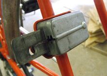 Speichenschloss Zeitraum: 1987 bis 1990 Verwendung: serienmäßig an Sporträdern von Mifa Material: Stahl, verzinkt Hersteller: ?? Prägung: keine Bekannte Farben: Bemerkungen: Befestigung an einer am Hinterbau angelöteten Halterung