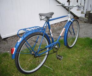 ==============================================] Mitte der 1970er Jahre war die Vielfalt bei den Fahrrädern und Fahrradteilen bereits deutlich zurückgegangen. Dieses Fahrrad trägt die typischen Anbauteile dieser Zeit (z.B. Beleuchtungsanlage von FER, Tourensattel mit Gummidecke von Möve). Das hier erkennbare Mifa-Emblem auf dem hinteren Schutzblech entfiel schon bald im Zusammenhang mit einem neuen Rahmendekor.