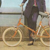 Dieses Klapprad (Katalogabbildung 1969) besitzt dementsprechend schon den typischen Hochlenker ohne Vorbau sowie eine überarbeitete Schnellspanneinrichtung für den Lenker. Hier ist allerdings das Rahmendekor bemerkenswert, zu dem noch keine weiteren Einzelheiten bekannt sind.