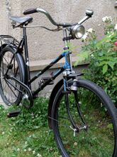 Ungewöhnlich für ein Tourenrad sind die Flügelmuttern, sie wurden möglicherweise zeitgenössisch nachgerüstet. Das Sattelgestell ist noch original, wurde jedoch später mit einer Decke aus Gummi versehen.