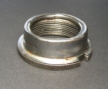 Abschlussmutter F Zeitraum: 1970er/1980er Jahre, spätestens ab 1975 Material: Stahl, verchromt, verzinkt Bemerkungen: zweiteilig, verschromte Blechkappe auf Gewindering gepresst. Offenbar parallel zur nachstehenden Abschlussmutter produziert.