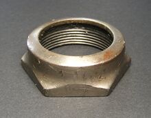 Abschlussmutter A Zeitraum: vrmtl. 1940er/frühe 1950er Jahre Material: Stahl, vernickelt Bemerkungen: einteilig, flachere Ausführung als nachstehende Abschlussmutter