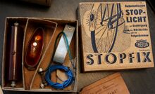 Lieferumfang des "STOPFIX" für Felgenbremse; links neben dem blauen Kabel findet sich der Kontaktgeber zur Montage an der Bremse.