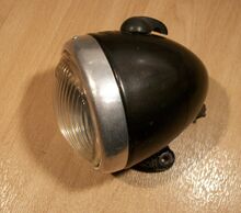 Scheinwerfer Typ ?? Zeitraum: 195x bis 195x (belegt für 1956/57) Verwendung: Mifa Fahrräder Material: Duroplast, Glas, Aluminium Ø Lichtaustritt: Farben/Varianten: schwarz, silber Bemerkungen: Mit Fahr- und Bodenlicht.