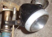 Zeitraum: um 1954 Verwendung: v.a. Diamant Fahrräder Material: Kunststoff, Glas, Aluminium Farben/Varianten: schwarz Bemerkungen Gehäuse aus Kunststoff; Lampenring aus Aluminium (seltener auch verchromtes Stahlblech); mit Fahr- und Bodenlicht