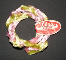 Nabenputzringe "Wüma RECORD" Zeitraum: hier: nach 1967 Hersteller: Wünsche & Co, Marienberg/VEB Zellstoffverarbeitung Material: Chenilledraht Bemerkungen: Zweifarbig, mehrere Farbkombinationen bekannt. "Doppeltstarke mehrfarbige Fahrrad-Naben-Putzringe". Produziert bis vrmtl. Ende der 1980er Jahre.