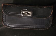 Satteltasche von vom VEB Lederwarenfabrik Mühlhausen Zeitraum: ca. 1955 Material: Leder, lackiert Bekannte Farben: Mittelbraun, schwarz Verwendung: Diamant-Sport-, Tourensport- und Tourenräder, Mifa-Sporträder Bemerkungen: mit rückseitiger Punze